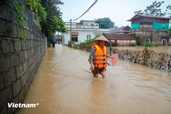Người dân di chuyển đồ đạc quý giá khỏi vùng ngập. (Ảnh: Hoài Nam/Vietnam+)