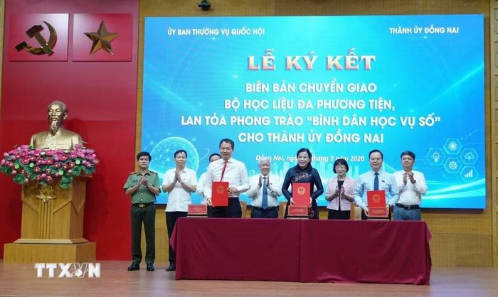 Nghi thức ký biên bản bàn giao giữa 3 bên gồm: Ủy ban Thường vụ Quốc hội, Thường trực Thành ủy Đồng Nai và đại diện chủ biên, tác giả bộ học liệu. (Ảnh: Sỹ Tuyên/TTXVN)