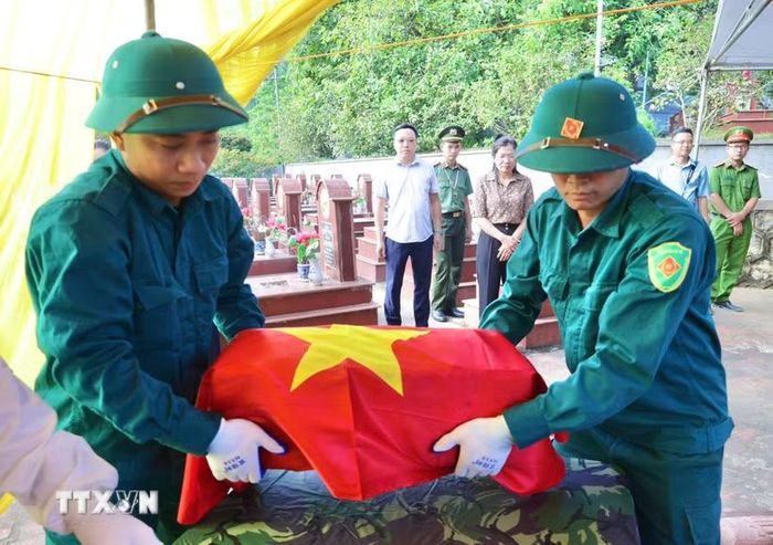 Lực lượng chức năng thực hiện nhiệm vụ tại Nghĩa trang Liệt sỹ La Giang, xã Quang Sơn. (Ảnh: Thu Hằng/TTXVN)