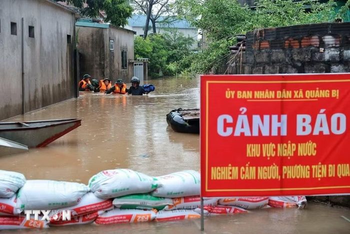 Cán bộ, chiến sỹ Trung đoàn 102, Sư đoàn 308 làm nhiệm vụ tại khu vực bị ngập sâu. (Ảnh: Phạm Tuấn Anh/TTXVN)