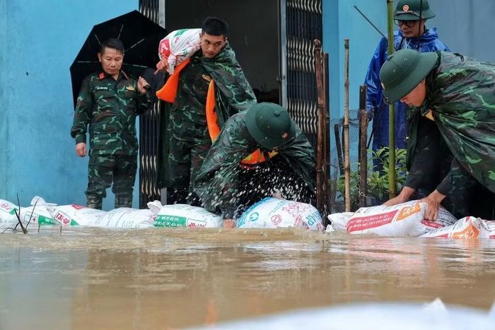 Cán bộ, chiến sỹ Trung đoàn 102 xếp các bao vật liệu tạo tuyến ngăn nước, bảo vệ nhà dân tại xã Quảng Bị. (Ảnh: Phạm Tuấn Anh/TTXVN)