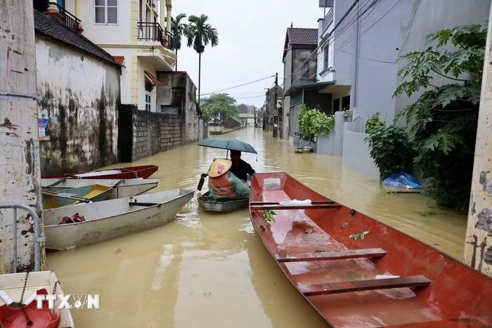 Khu dân cư ven sông Bùi ngập trong nước lũ, người dân phải dùng thuyền để di chuyển. (Ảnh: Nhật Anh/TTXVN)