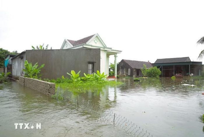 Mực nước sâu gần 1m bủa vây và gây biệt lập một cụm dân cư trên địa bàn xã Quỳnh Lưu (tỉnh Nghệ An) trong chiều 17/9. (Ảnh: Xuân Tiến/TTXVN)