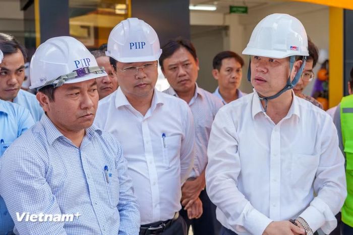 Đại diện Ban quản lý dự án báo cáo cơ chế vận hành và khả năng thoát nước mới được đầu tư tại khu vực đường Nguyễn Văn Linh cho Chủ tịch Ủy ban nhân dân thành phố Đà Nẵng Nguyễn Mạnh Hùng (hình phải, người ngoài cùng bên phải). (Ảnh: Thanh Phong/Vietnam+)