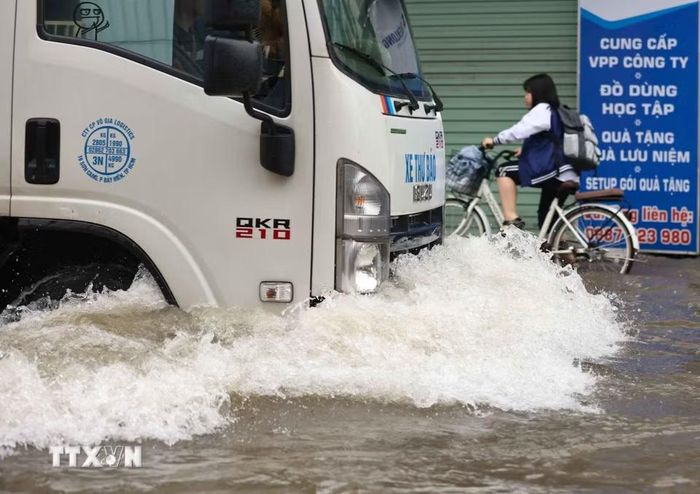Nhiều ôtô cố gắng di chuyển qua đường Tây Mỗ đang bị ngập. (Ảnh: Thanh Tùng/TTXVN)