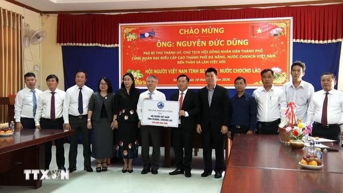 Lãnh đạo thành phố trao tặng 100 triệu đồng cho Hội người Việt Nam tỉnh Xekong. (Ảnh: Xuân Tú/TTXVN)