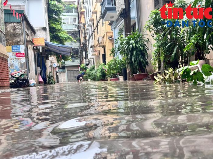 Sáng 17/9, tại nhiều tuyến phố tại Hà Nội nước ngập sâu, nhiều phương tiện phải di chuyển chậm, tìm những phần đường còn ít ngập để lưu thông.