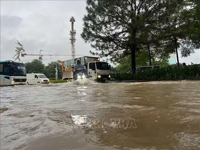Đường ngập sâu trong nước, các phương tiện di chuyển khó khăn. Ảnh: Nguyễn Thắng/TTXVN