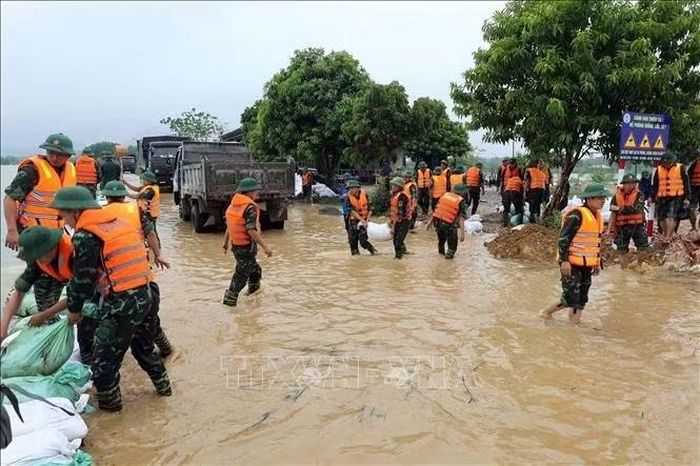 Các chiến sĩ thuộc tiểu đoàn 3 Lữ đoàn xe tăng 201 đắp các đoạn đê trũng, thấp trên tuyến đê Bùi 2. Ảnh: Nguyễn Cúc/TTXVN