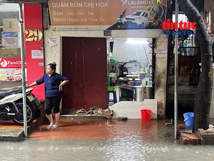 Đường phố ngập úng gây ảnh hưởng đến việc kinh doanh của các tiểu thương.