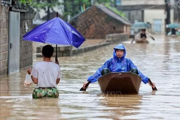 Nước lũ dâng cao, người dân phải sử dụng thuyền nhỏ để di chuyển tại xã Quảng Bị, Hà Nội. Ảnh: Phạm Tuấn Anh/TTXVN