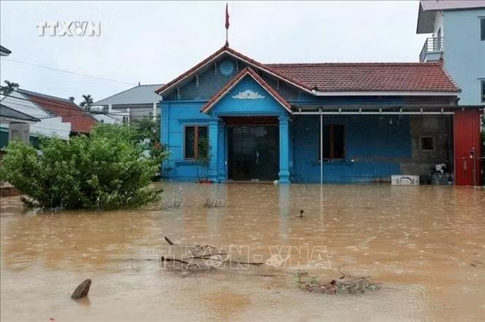 Nước lũ dâng cao tràn vào sân và bao vây nhà dân tại xã Quảng Bị, Hà Nội. Ảnh: Phạm Tuấn Anh/TTXVN