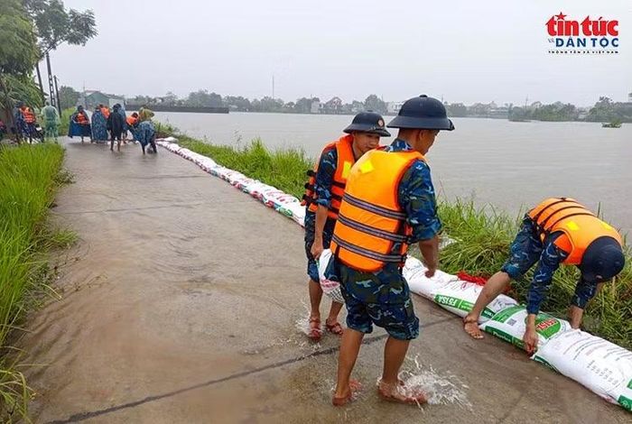 Cán bộ, chiến sĩ Tiểu đoàn 31 phối hợp với lực lượng tại chỗ và người dân đóng bao đất, gia cố đê.