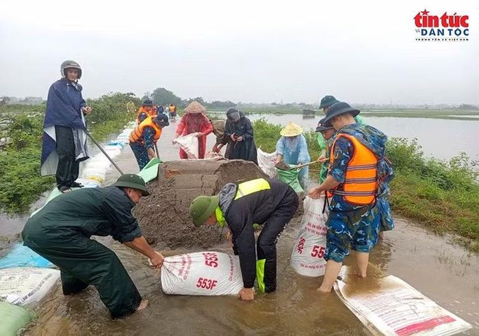 Tuyến đê Gò Khoăm bị nước bao quanh sau nhiều ngày mưa lớn; bộ đội và lực lượng địa phương khẩn trương triển khai phương án bảo vệ. Cán bộ, chiến sĩ Tiểu đoàn 31 phối hợp với lực lượng tại chỗ và người dân đóng bao đất, gia cố đê.