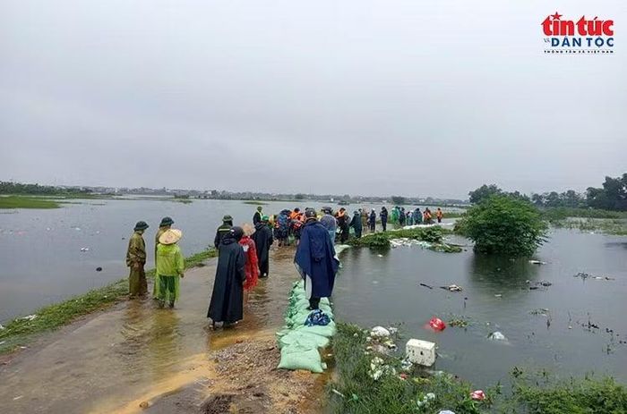 Những bao đất, cát được xếp nối dài dọc bờ đê, góp phần ngăn nước tràn vào khu dân cư và đồng ruộng.
