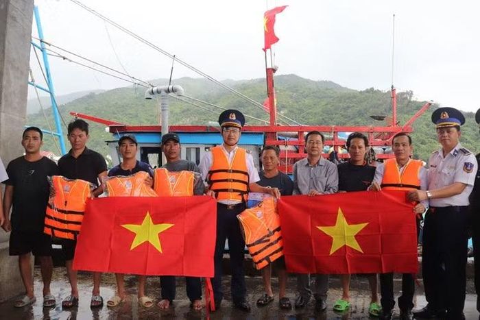 Đại tá Cao Xuân Quận, Phó Chính ủy Vùng tuyên truyền và tặng cờ Tổ quốc, áo phao, túi thuốc cho ngư dân.