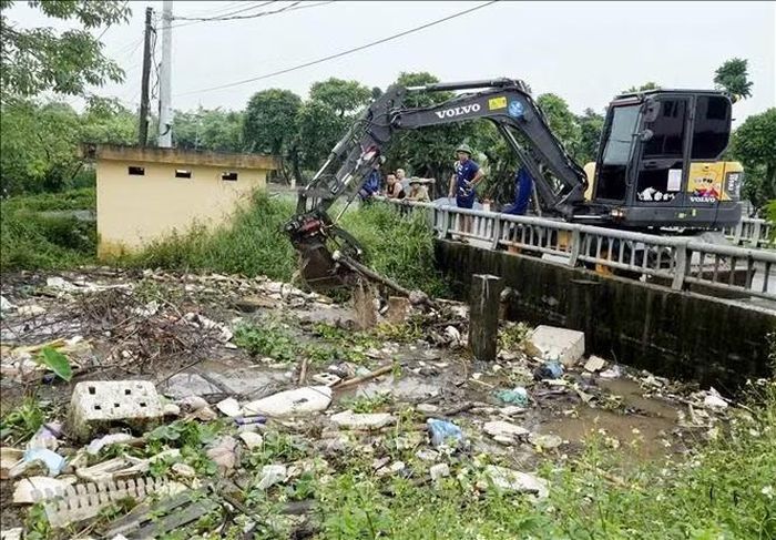 Xã Nghĩa Trụ tổ chức khơi thông dòng chảy nhằm nhanh chóng tiêu thoát nước mưa trên địa bàn. Ảnh: Mạnh Khánh/TTXVN