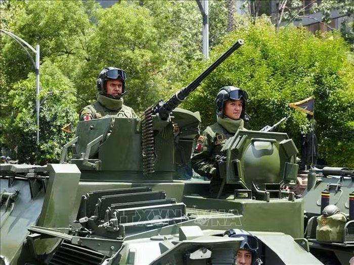 Nữ chiến sĩ điều khiển xe thiết giáp bọc thép trong trạng thái sẵn sàng làm nhiệm vụ, khẳng định vai trò bình đẳng và quan trọng của người phụ nữ trong lực lượng vũ trang. Ảnh: Phi Hùng/PV TTXVN tại Mexico