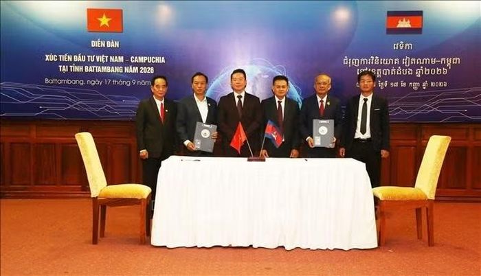 Lễ ký kết bản ghi nhớ hợp tác giữa Hội Doanh nhân Campuchia - Việt Nam (trái) và Đại học Quốc gia Battambang (phải) tại diễn đàn. Ảnh: Minh Hưng/PV TTXVN tại Campuchia
