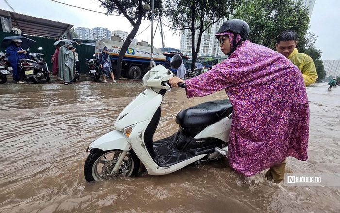 Người dân phải dò dẫm dắt xe máy qua khu vực ngập.