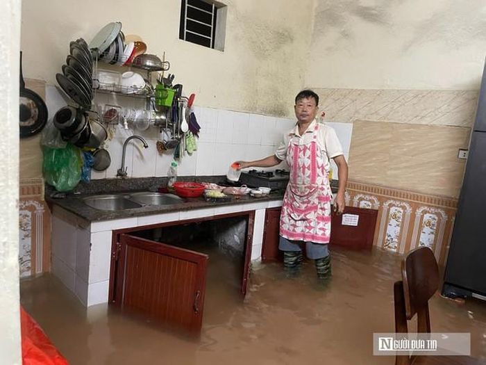 Ông Sơn nấu ăn trong bếp đầy nước đục ngầu.