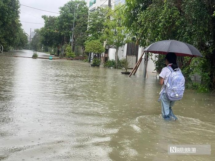 Học sinh bì bõm lội nước về nhà sau tan trường.