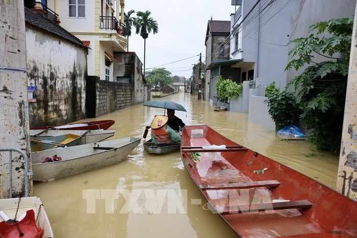 Khu dân cư ven sông Bùi ngập trong nước lũ, người dân phải dùng thuyền để di chuyển. Ảnh: Nhật Anh - TTXVN 