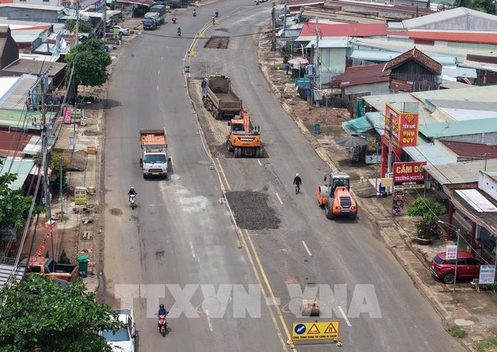 Đơn vị thi công đào bóc, xử lý kết cấu mặt đường tại một đoạn tuyến ĐT.759B qua khu dân cư xã Tân Tiến. Ảnh: Đậu Tất Thành - TTXVN