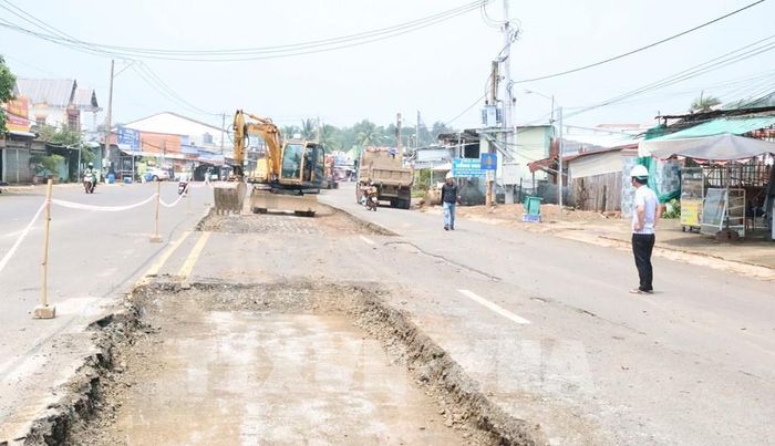 Đơn vị thi công đào bóc nền, mặt đường tại một vị trí hư hỏng trên ĐT.759B để xử lý, gia cố trước khi hoàn trả mặt đường. Ảnh: Đậu Tất Thành - TTXVN