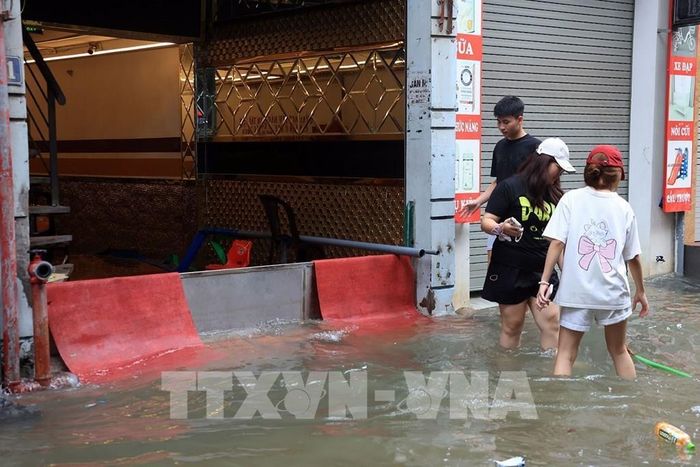 Một cửa hàng chặn nước để không tràn vào nhà. Ảnh: Tuấn Anh - TTXVN