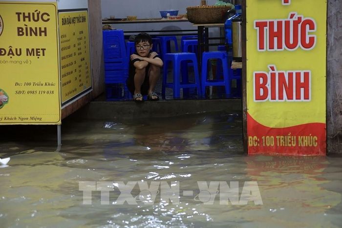 Phố Triều Khúc, phường Thanh Liệt vẫn ngập sâu, cuộc sống của người dân bị ảnh hưởng, các phương tiện giao thông gặp khó khăn khi đi qua tuyến đường này. Ảnh: Tuấn Anh - TTXVN 