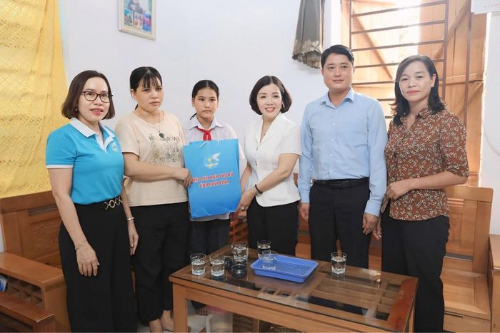 Chủ tịch Hội LHPN tỉnh Ninh Bình Đào Thị Hoà (thứ 3 từ phải sang) trao quà cho cháu Bùi Mai Anh