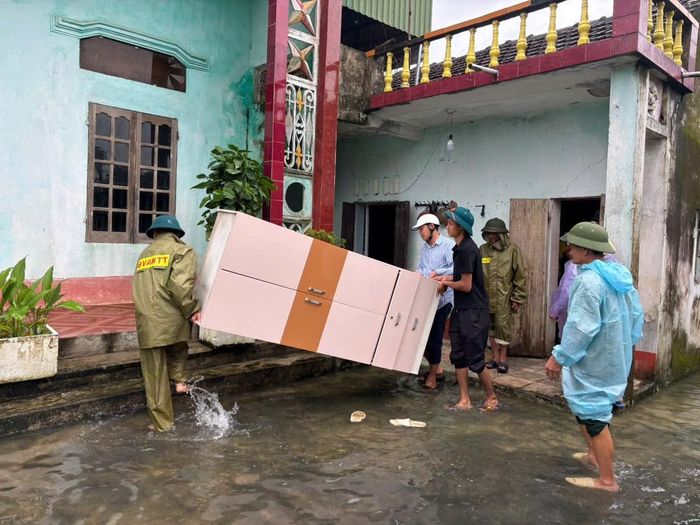 Các lực lượng phối hợp người dân di chuyển tài sản đến nơi an toàn tại xã Đồng Tiến