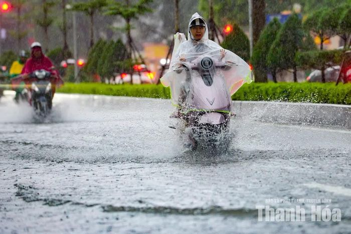 Người đi xe máy phải giảm tốc độ, lựa chọn những vị trí ít nước để di chuyển.