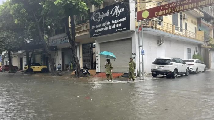 Lực lượng an ninh trật tự ở cơ sở đang túc trực phân luồng, hướng dẫn người dân lưu thông qua đoạn ngập trên tuyến đường Đội Cung.