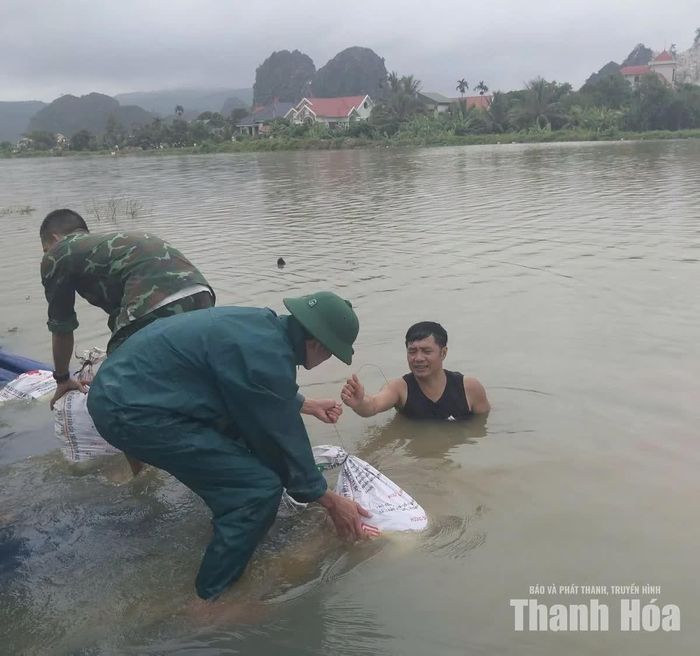 Cán bộ, lực lượng tại chỗ vận chuyển bao vật liệu phục vụ gia cố, bảo đảm an toàn tại khu vực bị ảnh hưởng bởi mưa lũ.