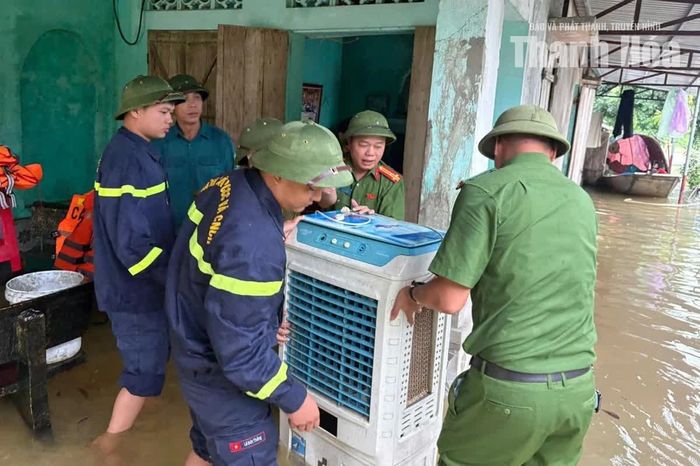 Cán bộ, chiến sĩ Công an xã Triệu Sơn hỗ trợ người dân di chuyển đồ đạc, tài sản đến nơi an toàn.