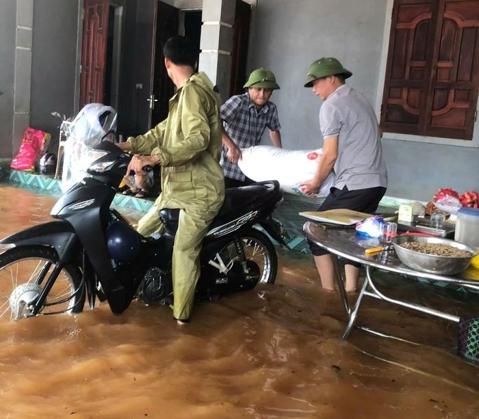 Lực lượng chức năng xã Nghĩa Lộc hỗ trợ người dân di chuyển người và vật nuôi khỏi khu vực ngập sâu.