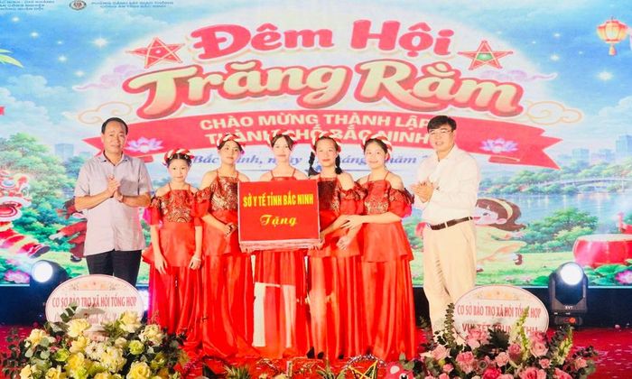 Lãnh đạo Sở Y tế (bên trái) tặng quà Cơ sở Bảo trợ xã hội tổng hợp tỉnh và các em thiếu nhi đang được chăm sóc, nuôi dưỡng tại đây.