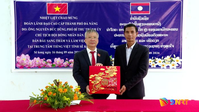 Chủ tịch HĐND thành phố Nguyễn Đức Dũng tặng quà cho Trung tâm tiếng Việt tỉnh Sê Kông. Ảnh: HOÀN VŨ - VĂN HÙNG