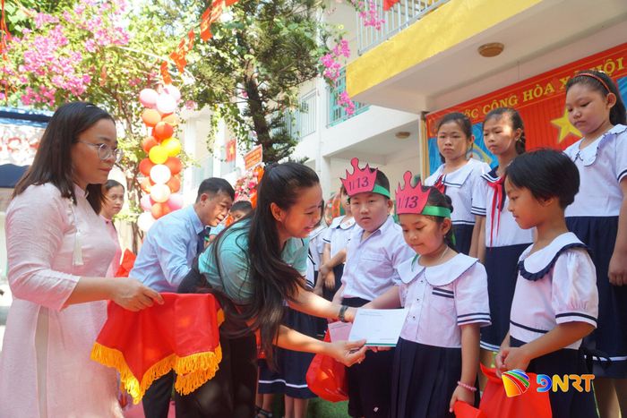 Học sinh có hoàn cảnh khó khăn tại Trường Tiểu học Hai Bà Trưng nhận thẻ BHYT từ chương trình kết nối của Bệnh viện Phụ sản - Nhi Đà Nẵng. Ảnh: NAM BÌNH