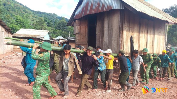Cán bộ, chiến sĩ Đồn Biên phòng A Nông cùng các lực lượng di dời căn nhà khỏi khu vực nguy hiểm. Ảnh HUỲNH CHÍN