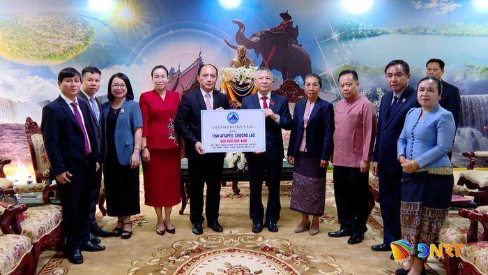 Lãnh đạo thành phố trao 500 triệu đồng hỗ trợ tỉnh Attapeu. Ảnh: HOÀN VŨ - VĂN HÙNG
