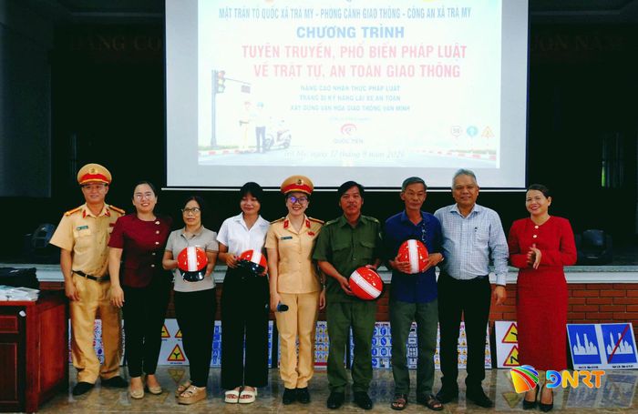 Trao tặng mũ bảo hiểm đạt chuẩn cho người dân tham gia chương trình. Ảnh: PHƯƠNG KHÁNH