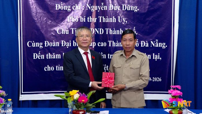 Chủ tịch HĐND thành phố Nguyễn Đức Dũng (bên trái) tặng quà cho Trung tâm tiếng Việt tỉnh Attapeu. Ảnh: HOÀN VŨ - VĂN HÙNG