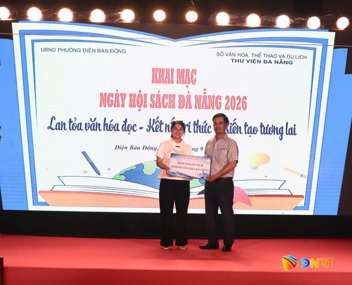 Đại diện Thư viện Đà Nẵng (bên phải) trao tặng tủ sách cho đại diện Trung tâm Cung ứng dịch vụ sự nghiệp công phường Điện Bàn Đông. Ảnh: QUỐC TUẤN