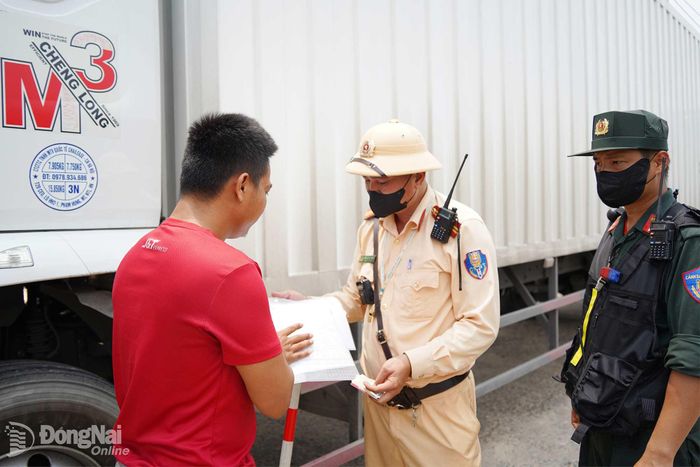 Lực lượng cảnh sát giao thông kiểm tra phương tiện vận tải lưu thông trên tuyến quốc lộ 1, nhắc nhở tài xế chấp hành các quy định về trật tự, an toàn giao thông. Ảnh: Lê Duy