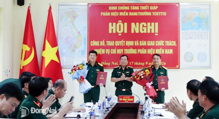 Thiếu tướng Đỗ Đình Thanh trao quyết định và tặng hoa chúc mừng Đại tá Đậu Huy Hoàng và Đại tá Nguyễn Anh Tuấn. Ảnh: Nguyệt Hà