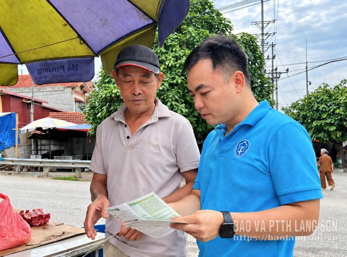 Cán bộ Bảo hiểm xã hội cơ sở Chi Lăng tuyên truyền đến người dân về chính sách bảo hiểm xã hội