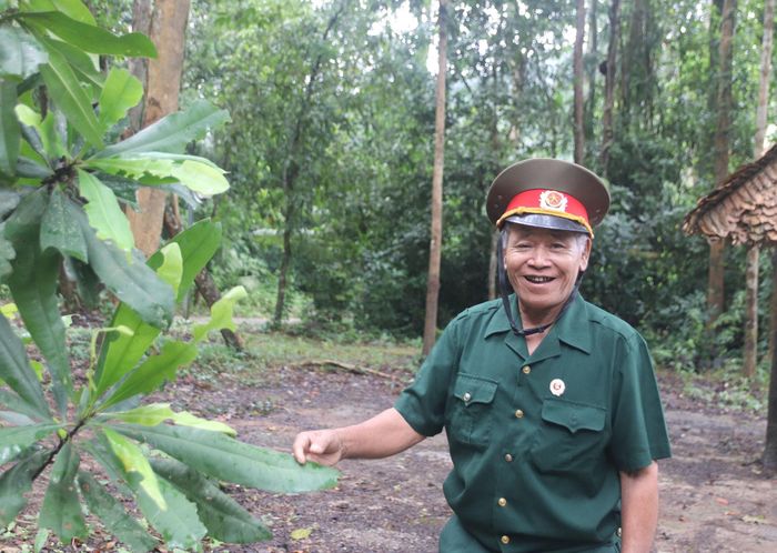 Cựu chiến binh K' Văn Dên đang chia sẻ với đoàn tham quan về cây trung quân